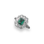 An emerald and diamond cluster ring, the octagonal-shaped emerald is set within a surround of ten