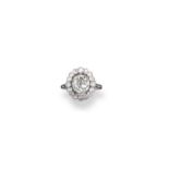 A diamond cluster ring, the cushion-shaped diamond set within a surround of old circular-cut