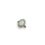 An opal and diamond cluster ring, the solid white opal cabochon is set within a surround of