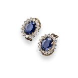 A pair of sapphire and diamond cluster earrings, each oval-shaped sapphire set within a surround