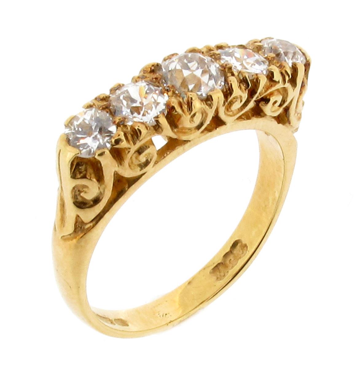 A diamond five stone ring, the graduated old circular-cut diamonds are set in carved and pierced