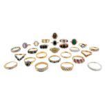 Twenty six gem set gold rings, including an emerald and diamond half hoop ring, three diamond half