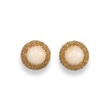 A pair of pink coral mounted gold earrings, the coral cabochons are set within plaited gold circular