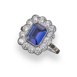 A tanzanite and diamond cluster ring, the emerald-cut tanzanite weighs approximately 1.25cts and