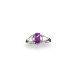A pink sapphire and diamond-set three stone ring, the oval-shaped pink sapphire is set with two