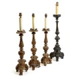 A set of three Italian giltwood altar table lamps, each with a leaf carved baluster stem on a