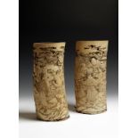 λ A pair of Japanese ivory tusk vases, carved in relief with country folk, carrying pails of water