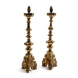 A pair of 18th century Italian giltwood altar table lamps, each with a knopped stem and on a