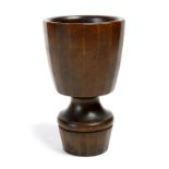 λ A 19th century German carved and turned rhinoceros horn goblet, the faceted bowl on