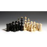 λ A 19th century continental ebony and ivory chess set, with turned and carved decoration, probably