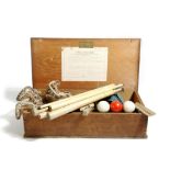 A table billiard set by Gamage, in a pine box, 12.3cm high, 48.5cm wide, 24.3cm deep.