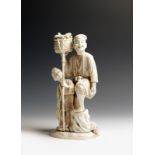 λ A Japanese carved marine ivory okimono, depicting a fisherman with his son