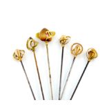 A collection of five Edwardian Charles Horner 9 carat gold hat pins, comprising one with a central