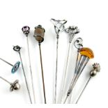 A collection of ten Charles Horner silver hat pins, comprising: one modelled as a grenade, one