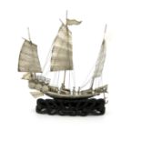 A Chinese silver model of a junk, circa 1920, the deck mounted with five canons, on a carved