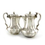 λA pair of William IV Irish silver coffee/hot water jugs, by Richard Sawyer, Dublin 1833, lobed