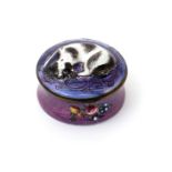 An enamel snuff box, c.1770, moulded with a recumbent black and white spaniel on a circular purple