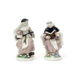 A pair of Bow figures of a monk and a nun, c.1755, both seated, the monk reading from a Bible or