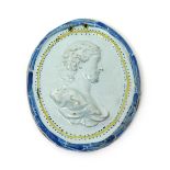 A Continental faïence portrait plaque, 18th century, moulded in high relief with a head and