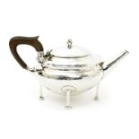 An A.E. Jones silver teapot, model no.67, on four square legs with round pad feet, hinged cover