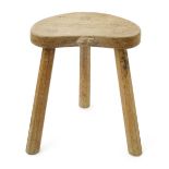 A Robert Mouseman Thompson oak calf stool, the kidney shaped seat on three flaring legs, with carved