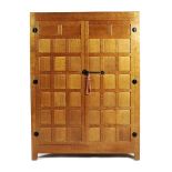 A Robert Mouseman Thompson oak wardrobe, with panelled doors, patinated wrought iron furniture,