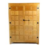 A Robert Mouseman Thompson oak wardrobe, with panelled doors, patinated wrought iron furniture,