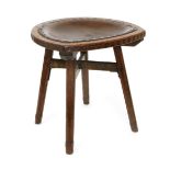 An oak stool designed by Arthur Romney Green, the shaped seat with leather pad, on four flaring