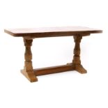 A Robert Mouseman Thompson oak low table, rounded rectangular top with adzed finish, on carved legs,