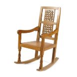 A Robert Mouseman Thompson oak Rocking chair, with studded leather seat, carved lattice back, carved