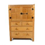 A Robert Mouseman Thompson oak Tallboy, three drawers, supporting two panelled door fitted bureau