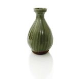 ‡ Bernard Leach (1887-1979) a stoneware vase, spiralling faceted form covered to the foot in a