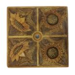 A Martin Brothers stoneware tile, moulded in low relief with panels of sunflowers, in brown and