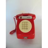 A vintage red Bakelite cased payphone unit bearing metallic plaque with '20 cents' aperture and