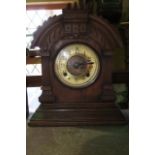 An Ansonia mantle clock in a carved oak case with eight day striking movement