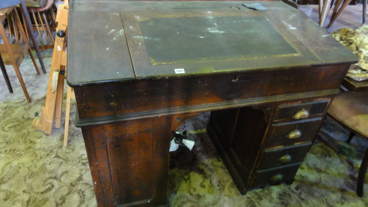 A Victorian oak kneehole and twin pedestal clerks desk with central hinged slope over a cupboard and