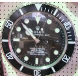 A Rolex wall clock, the dial in the form of the Oyster Perpetual Date Submariner within a black