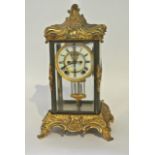 A 19th century cast and gilded brass 4 pane mantle clock, the dial with visible escapement and