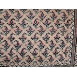 An eastern wool rug with pale field interspersed with symmetric medallions in pink, blue and