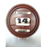 A 20th century wall mounting timber framed perpetual calendar of circular form with three