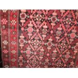 An eastern style wool work carpet, the dark ground interspersed with symmetric medallions in
