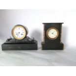 A Victorian black slate mantle clock, the drum movement set within a circular case raised on a