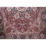 A pair of eastern style wool carpets, the deep red grounds interspersed with a complex foliate