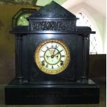 An Ansonia black slate mantle clock of classical outline with visible escapement and 8 day