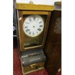 A National Time Recorder Co Ltd oak cased clocking in and out clock with circular dial and Roman