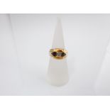 An 18ct gold ring, the central diamond flanked by two triangular cut sapphire, size M
