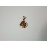 A 14ct gold pendant of swirled design supporting a central ruby