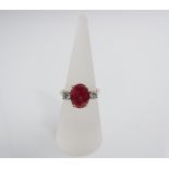 An 18ct gold ruby ring, the central stone flanked by two diamonds, size O