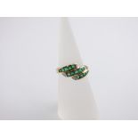 An 18ct gold emerald and diamond set ring in three bands, size L