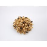 A mid 20th century 9ct gold brooch of abstract floral design, set with nine sapphires, 26 gms